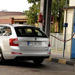 Srebrna Skoda tankuje gaz ziemny (CNG). Stacja paliw z dystrybutorem CNG.